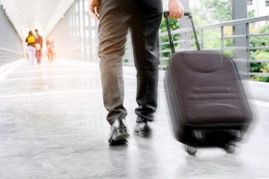 Businessman holding trolley bag going up on travel
