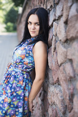 Fototapeta premium Portrait of a beautiful girl near a stone wall