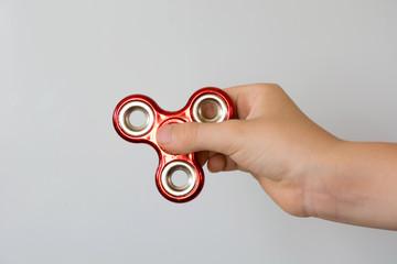 Fidget red spinner stress in hand on white.