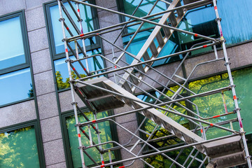 Metallic scaffolding in front of modern office building. 