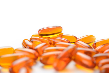 close up to pile of Fish oil capsules on a white background. soft gels capsules