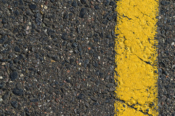 The texture of the asphalt is covered with yellow paint.