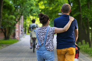 Obraz premium Young couple walking with child in the Park. Summer.