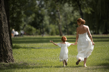 mother and daughter walking in park