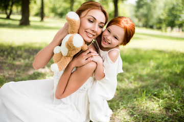 Fototapeta premium mother and daughter with teddy bear in park