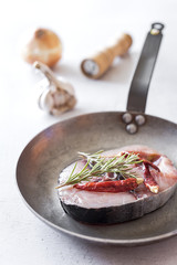 Raw tuna steak on plate and wooden table