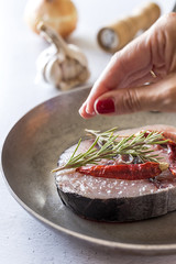 Raw tuna steak on plate and wooden table