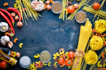 Pasta with vegetables, cherry tomatoes, chili peppers and garlic. On a wooden background. Free space for text . Top view.