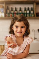 Little girl showing her cookie.