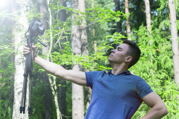 A young man photographs himself with a tripod