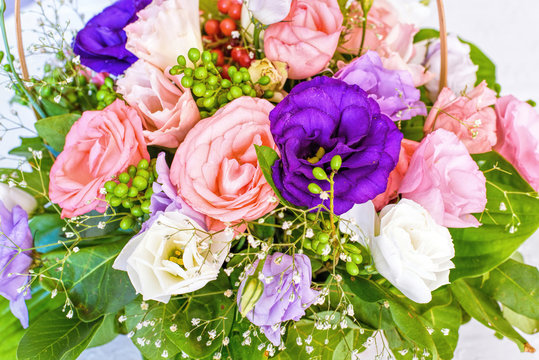 Summer flowers bouquet in a basket, white red and purple. 