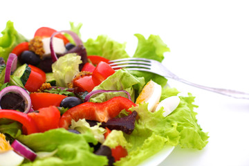 salad from fresh vegetables in a plate on a table, selective focus