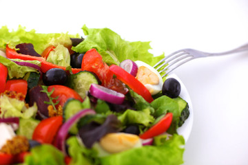 salad from fresh vegetables in a plate on a table, selective focus