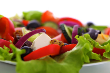 salad from fresh vegetables in a plate on a table, selective focus