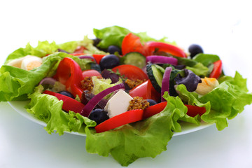 salad from fresh vegetables in a plate on a table, selective focus