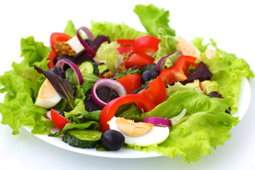 salad from fresh vegetables in a plate on a table, selective focus
