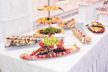 Delicious and tasty dessert table with cupcakes shots at reception closeup