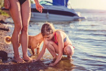 Mother, daughter and dog on the beach