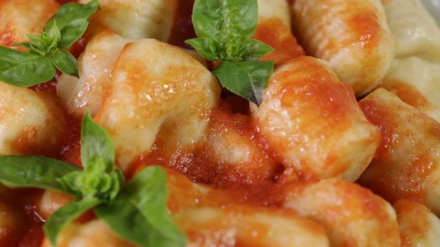 Gnocchi di patate italiani con salsa di pomodoro fresca, basilico in un piatto da ristorante.