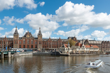 Obraz premium Canal cruise boat in front of Amsterdam central railway station in Amsterdam, Netherlands