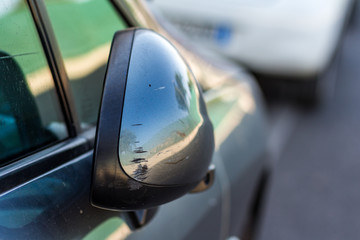 scratched side mirror of gray car 