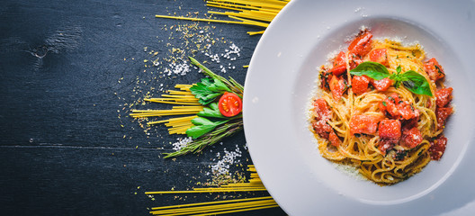 Pasta tomatoes. Italian traditional food. On a wooden background. Top view. Free space for your text.