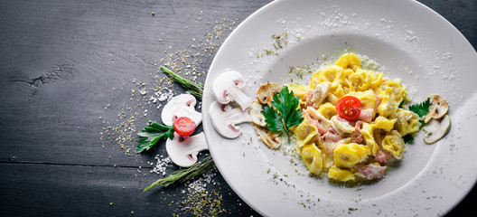 Dumplings in mushroom and cream sauce. Italian traditional food. On a wooden background. Top view. Free space for your text.