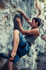 Men climbs an overhanging rock, bouldering