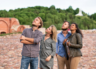 Group of young friends looking up with interest