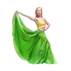 Beautiful young blonde girl in a yellow top, a long green skirt and a hairpin with a flower on her...