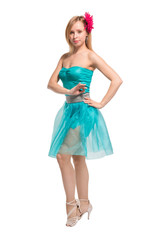 Beautiful young blonde girl in a blue top, blue skirt and a pink barrette in the shape of a flower on her head dancing