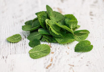 Mint leaves on a white wooden background