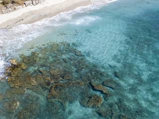 Vista aerea di scogli sul mare. Panoramica del fondo marino visto dall’alto, acqua trasparente. Nuotatori, bagnanti che galleggiano sull’acqua