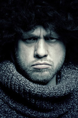 Angry man in a fur hat and a warm sweater. Toned