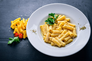 Pasta with cream sauce and parmesan cheese. Italian traditional food. On a wooden background. Top view. Free space for your text.