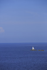 Lighthouse on rocks, Photo of white lighthouse on rocks with blue sea in the background