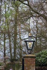Fototapeta na wymiar The old metal lantern on the stone column