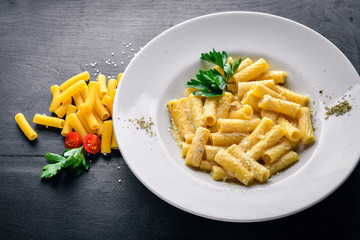 Pasta with cream sauce and parmesan cheese. Italian traditional food. On a wooden background. Top view. Free space for your text.