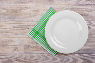 Empty plate over wooden table background. View from above with copy space