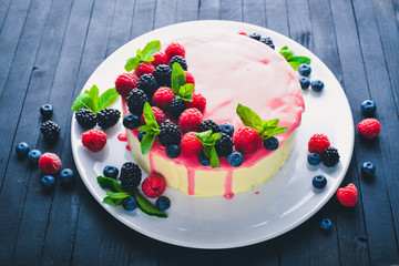 Cake with butter and fresh berries and fruits. Dessert. On a wooden background. Top view. Free space for your text.