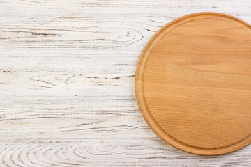 Empty round cutting board on a white kitchen top.