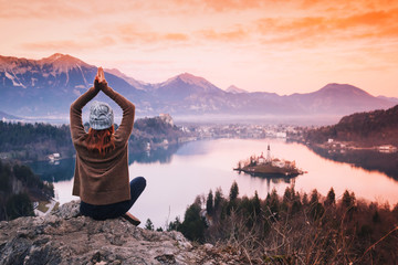 Traveling young woman looking on sunset on Bled Lake, Slovenia, Europe