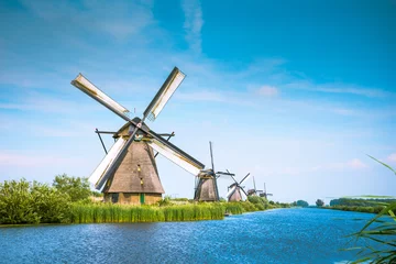 Gardinen Traditional village with dutch windmills and river at sunset, Holland, Netherlands. © gatsi