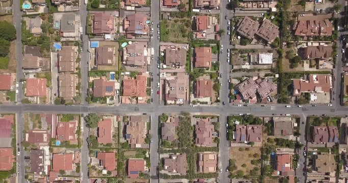 Vista aerea ortogonale di una parte del quartiere Marco Simone nella periferia nord a Roma. Tra le strade strette, le ville e i palazzi si vedono alberi. Sugli edifici ci sono antenne e parabole.