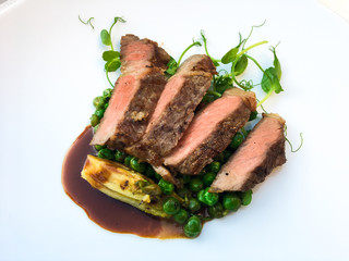 Juicy steak medium beef with green pea and sauce on beautiful plate