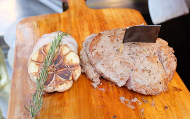 grilled beef steaks with spices on wooden cutting board.