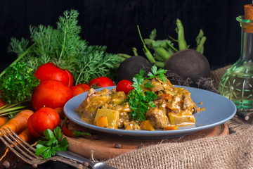 dish of stewed vegetables on a table with tomatoes and carrots
