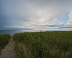 Nantucket ocean beach at sunrise with clouds and seagrass