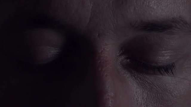 Close up of male eyes opening in fear after bad dream or nightmare in bed at night