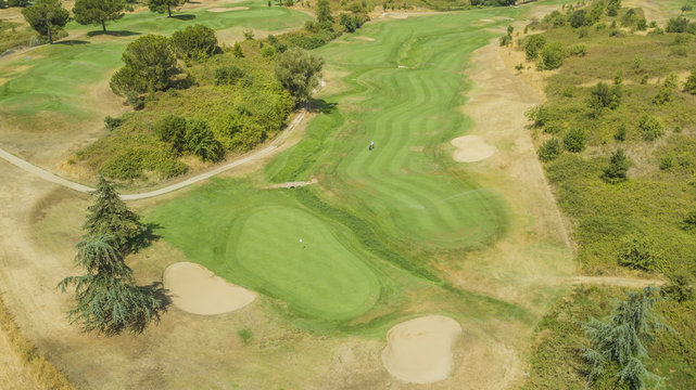 Vista aerea della buca finale del percorso di un campo di golf. Il prato fa parte di un ampio e ricco circolo di golf italiano frequentato dai migliori giocatori del panorama sportivo.